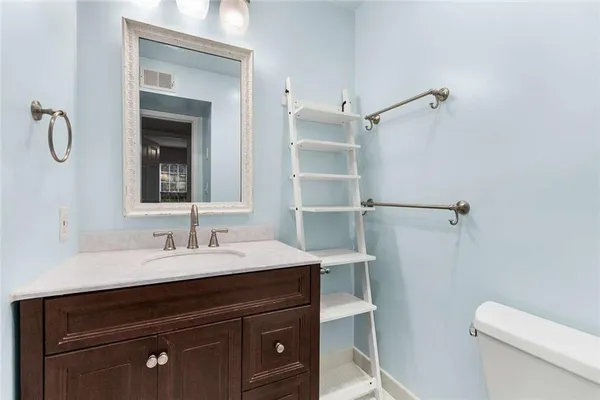 a bathroom with a sink vanity granite and toilet