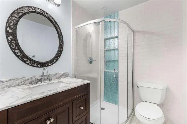 a bathroom with a granite countertop toilet a sink and a mirror