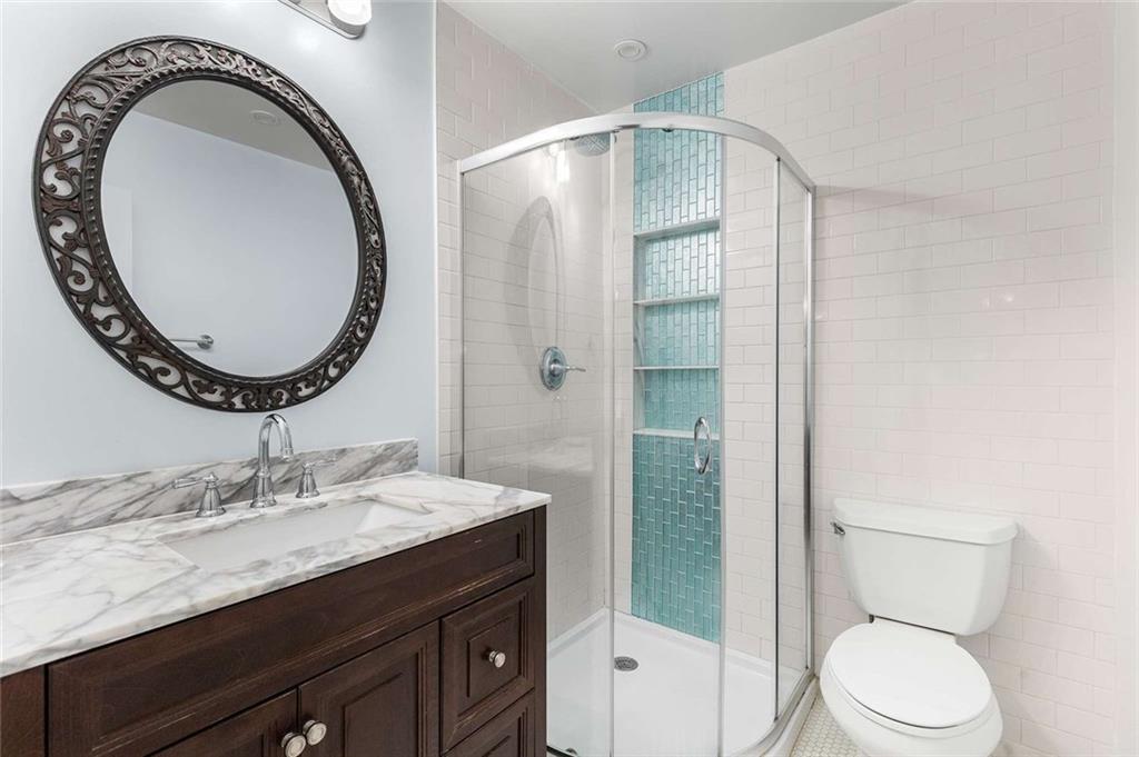1101 Collier Road Northwest, Unit P2 Atlanta, GA 30318 - Photo 20 of 26 a bathroom with a granite countertop toilet a sink and a mirror