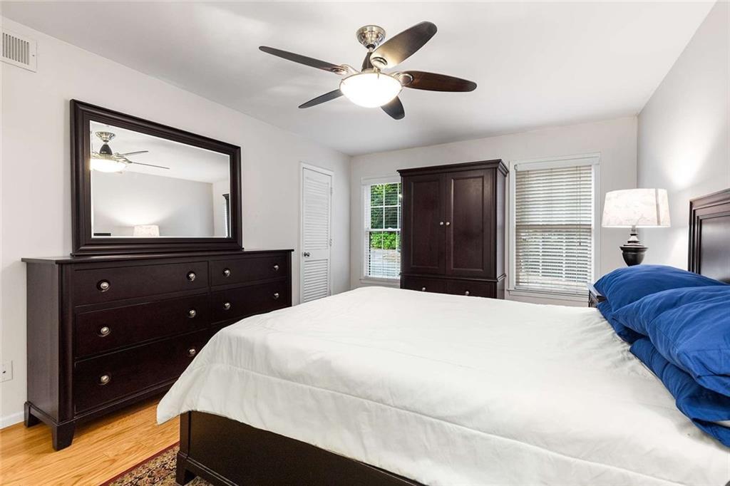 1101 Collier Road Northwest, Unit P2 Atlanta, GA 30318 - Photo 22 of 26 a bedroom with a bed and a dresser with a flat tv screen