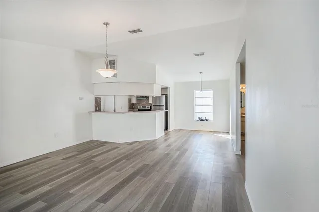 a view of empty room with wooden floor and window