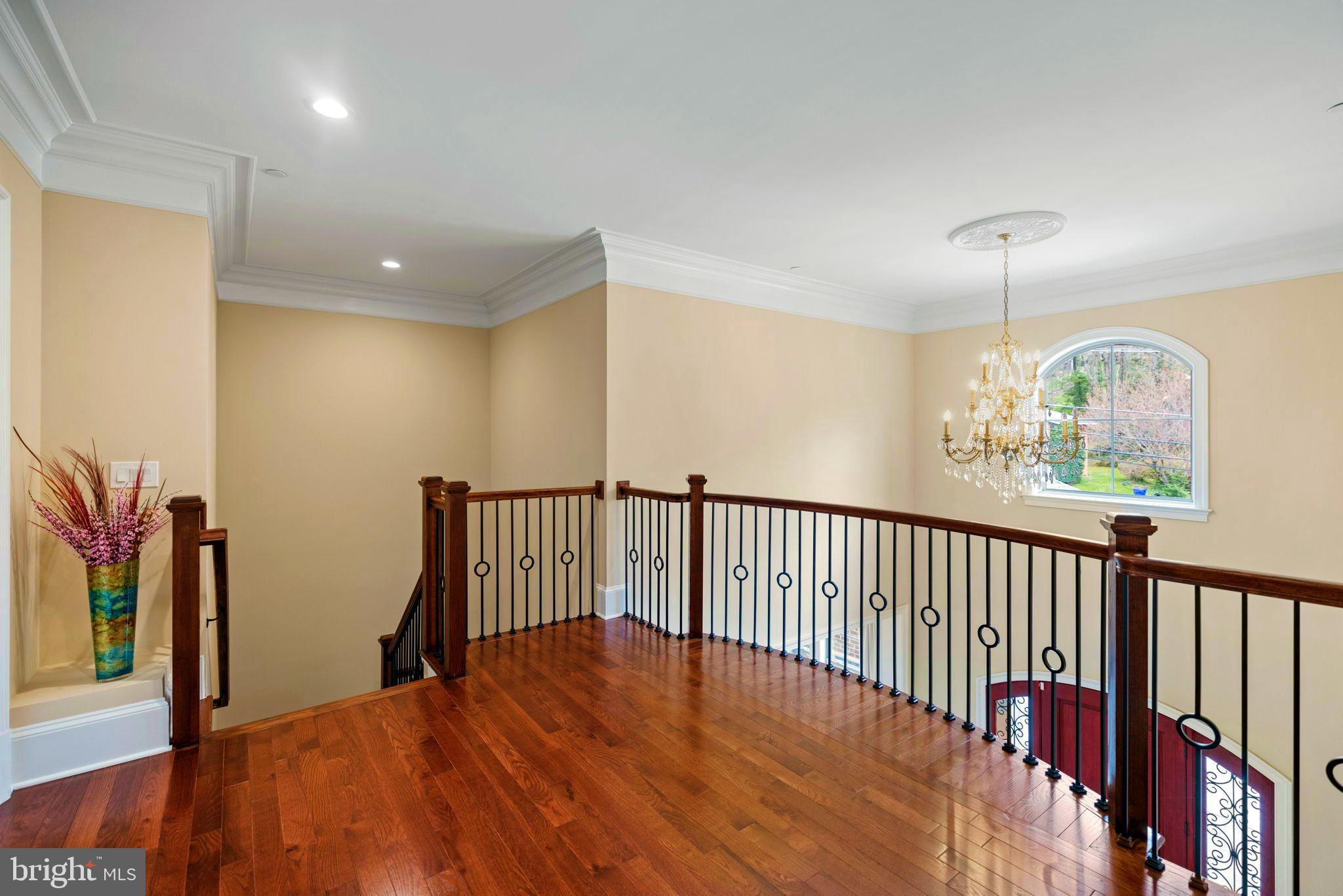 7708 Beech Tree Road Bethesda, MD 20817 - Photo 28 of 55 a view of a hallway with wooden floor and a chandelier