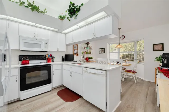a kitchen with white cabinets and sink