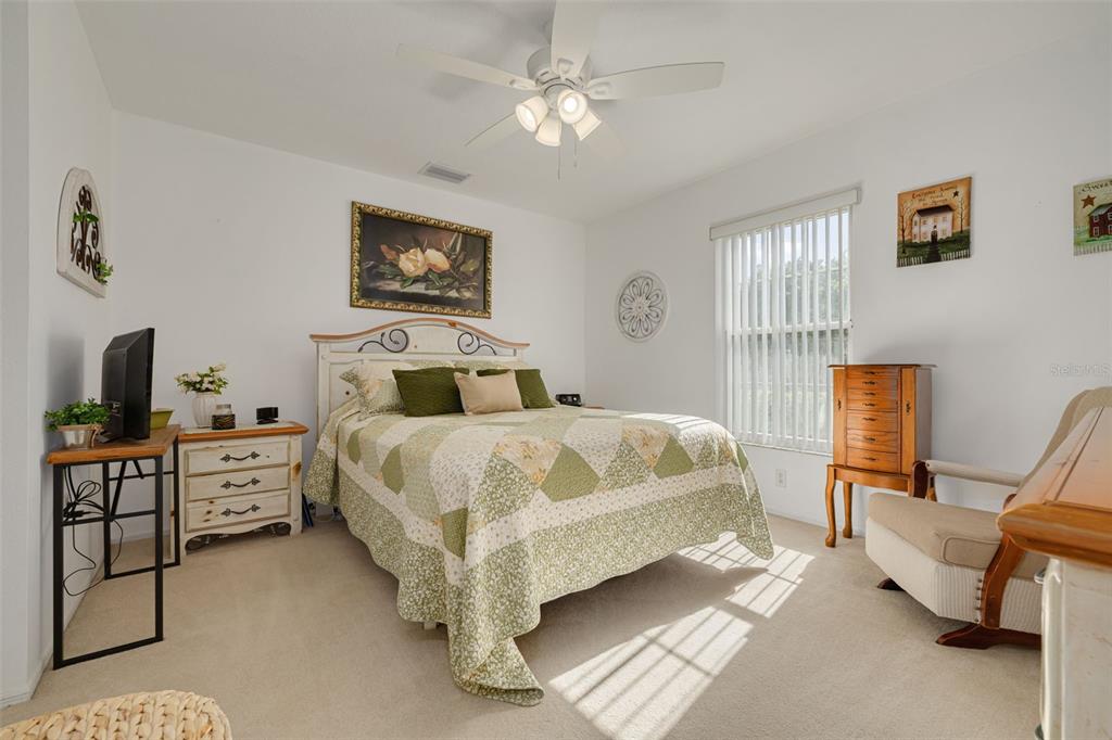 4245 Avanti Circle New Port Richey, FL 34655 - Photo 15 of 28 a bedroom with a bed a chair and a chandelier