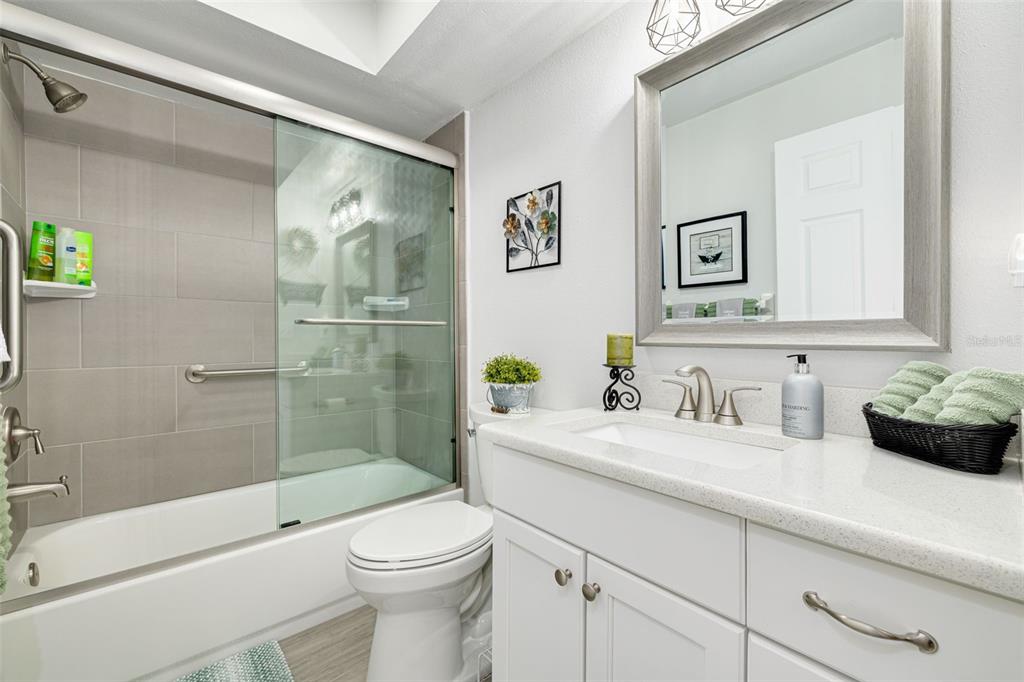 4245 Avanti Circle New Port Richey, FL 34655 - Photo 23 of 28 a bathroom with a granite countertop sink a toilet and shower