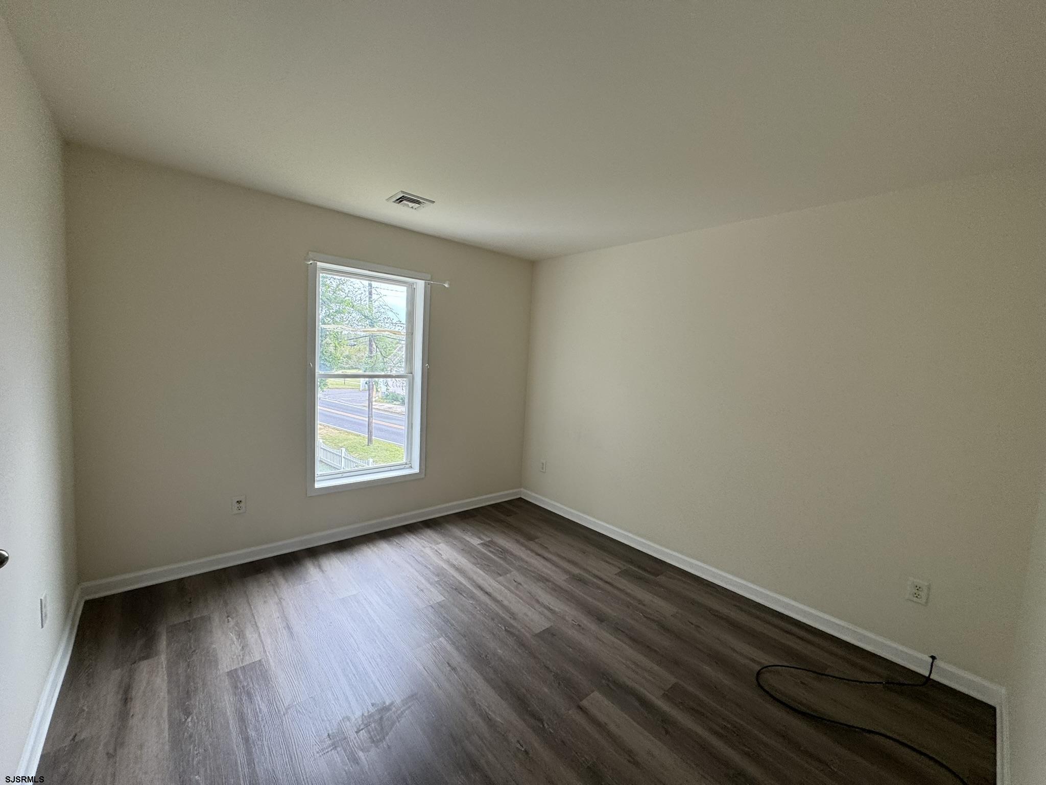 2192 West Avenue, Unit RIGHT SIDE Linwood, NJ 08221 - Photo 16 of 23 an empty room with wooden floor and windows