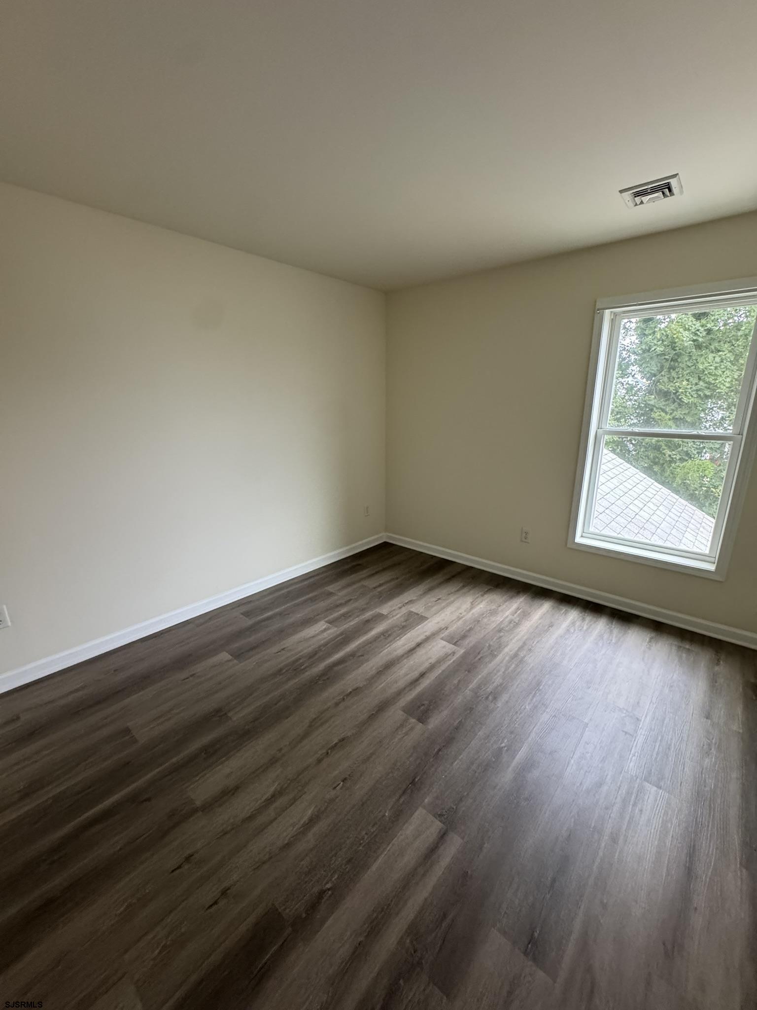 2192 West Avenue, Unit RIGHT SIDE Linwood, NJ 08221 - Photo 17 of 23 a view of an empty room with wooden floor and a window