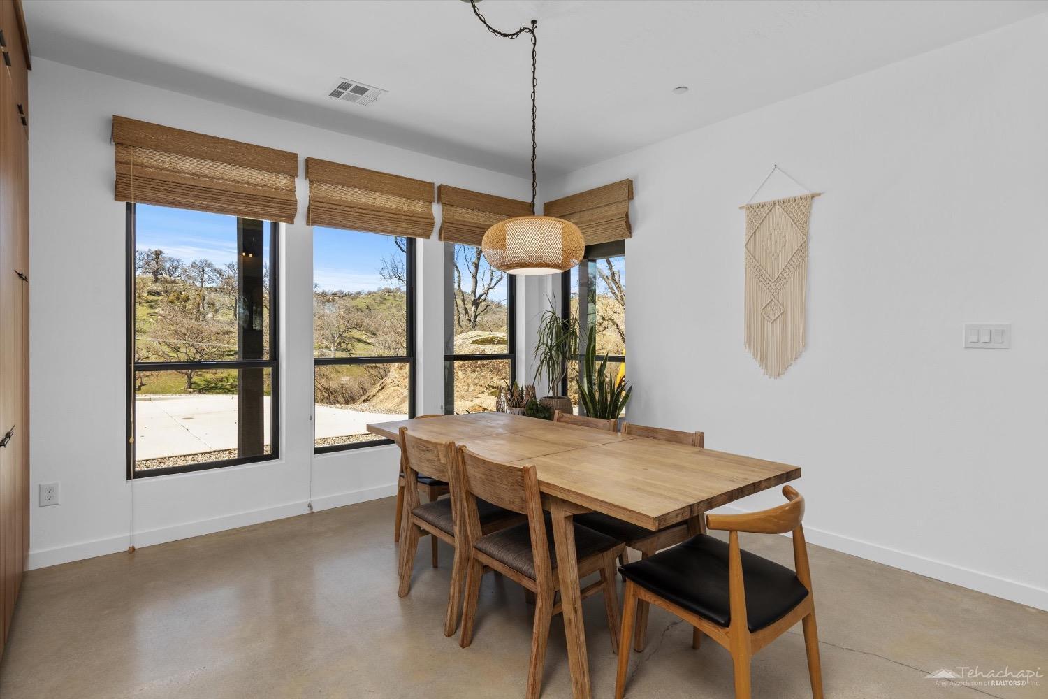 28901 Augusta Way Tehachapi, CA 93561 - Photo 24 of 65 a dining room with wooden floor a chandelier a wooden table and chairs