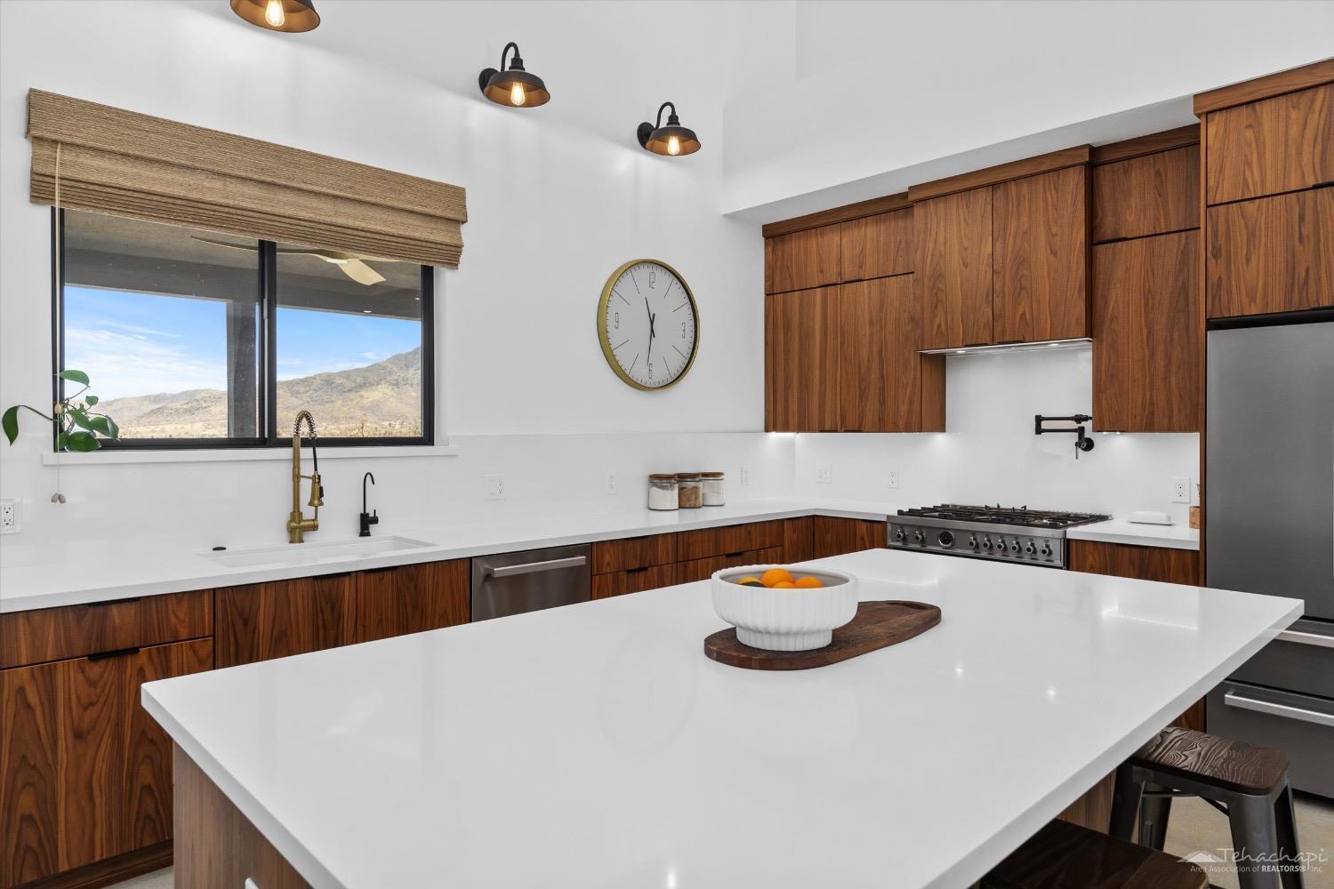 28901 Augusta Way Tehachapi, CA 93561 - Photo 29 of 65 a kitchen with a table a stove a sink and a refrigerator