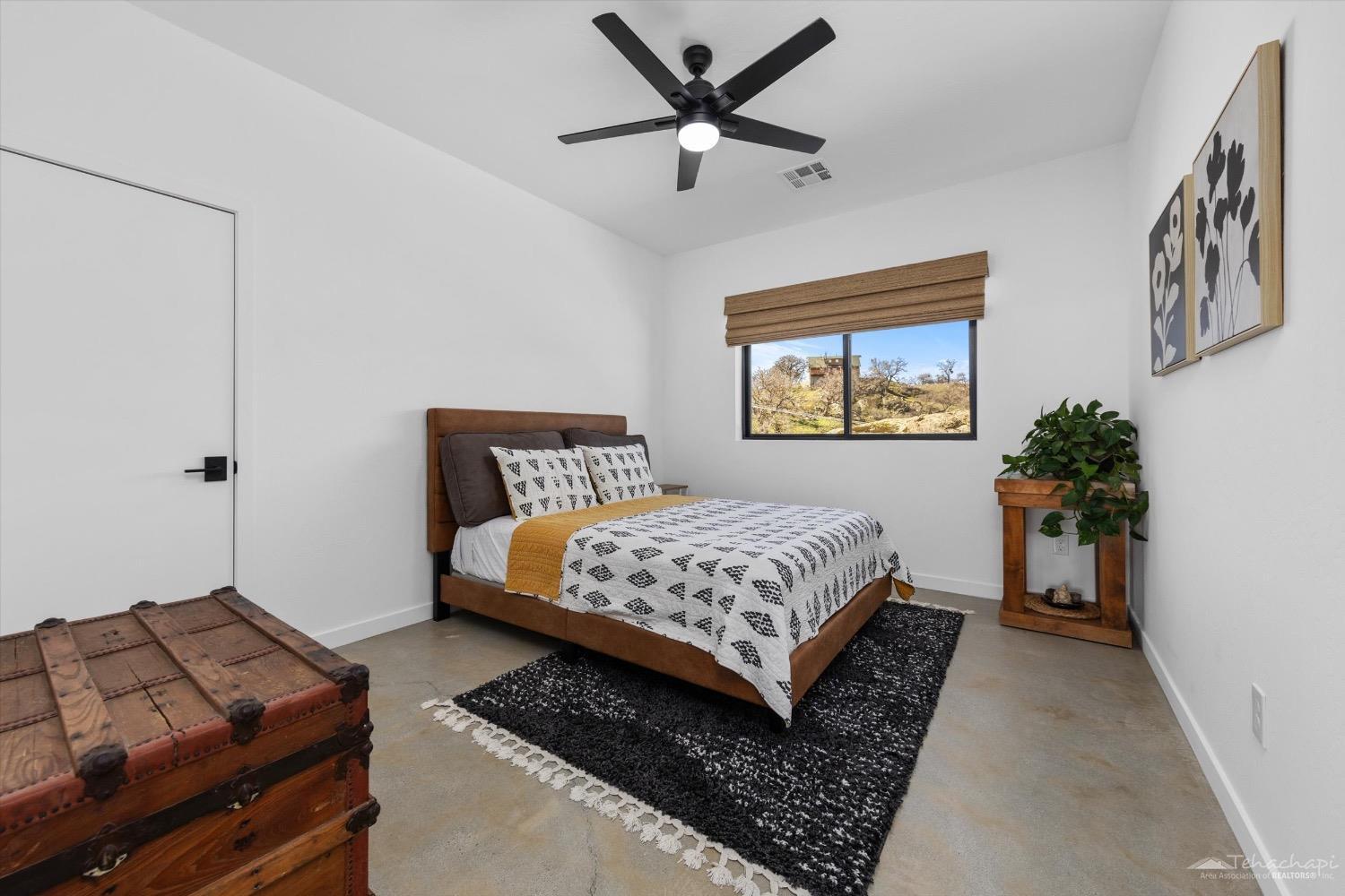 28901 Augusta Way Tehachapi, CA 93561 - Photo 41 of 65 a bedroom with a bed and a chandelier