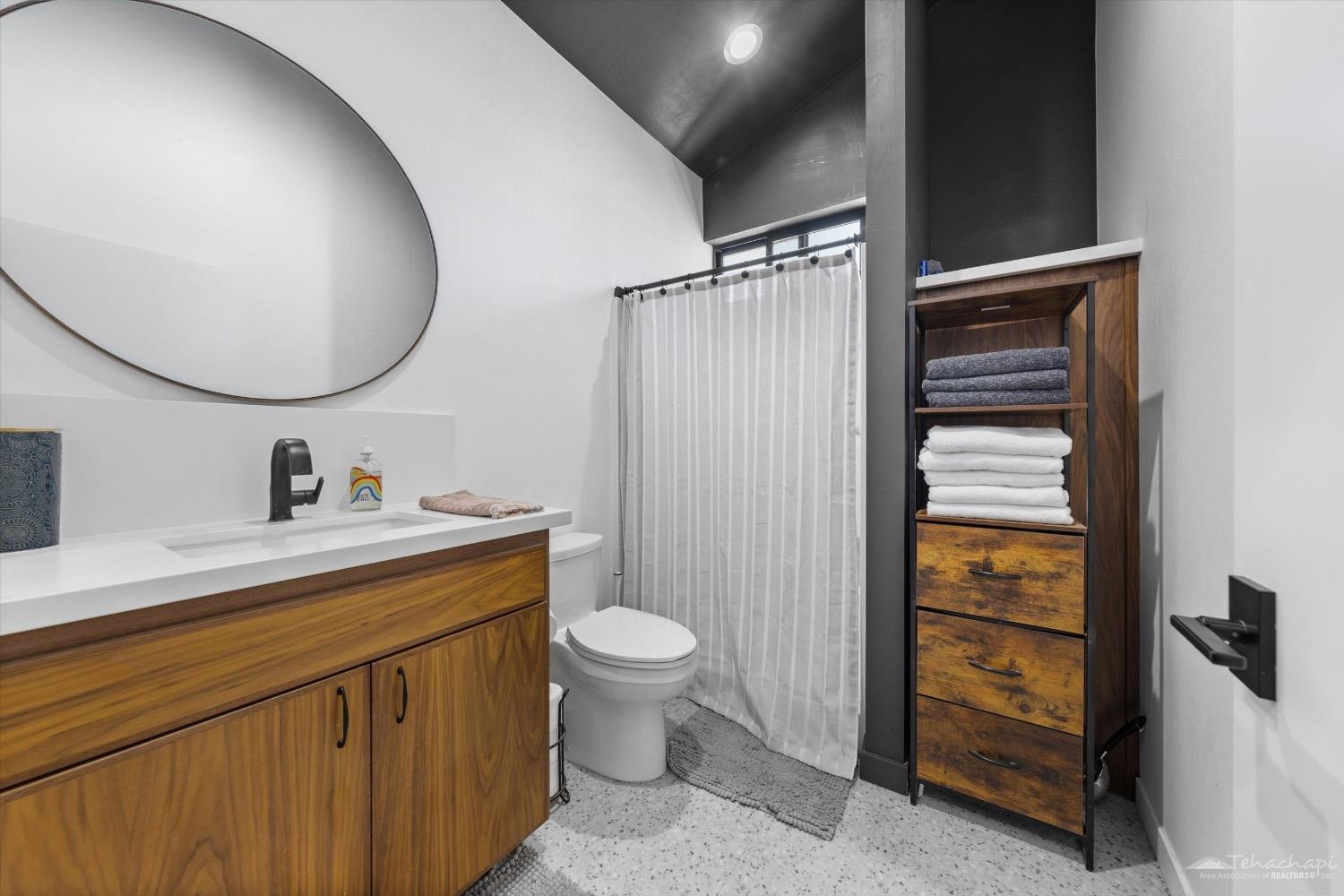 28901 Augusta Way Tehachapi, CA 93561 - Photo 53 of 65 a bathroom with a sink a toilet and a mirror