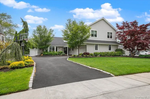a front view of a house with a yard and trees
