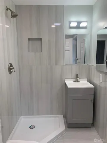 a bathroom with a sink a shower and a mirror