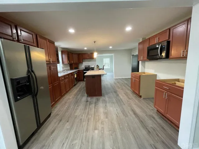 a kitchen with stainless steel appliances a refrigerator and a stove top oven