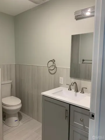a bathroom with a toilet a sink and mirror