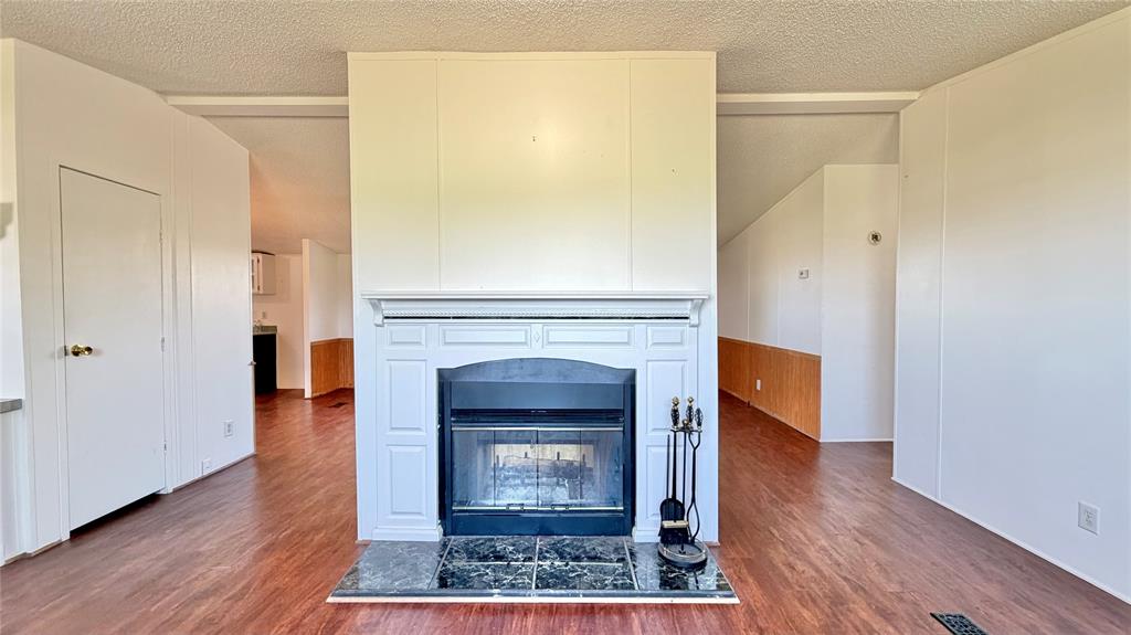 3789 Jacobs Lane Kaufman, TX 75142 - Photo 12 of 33 a living room with a fireplace and a wooden floor