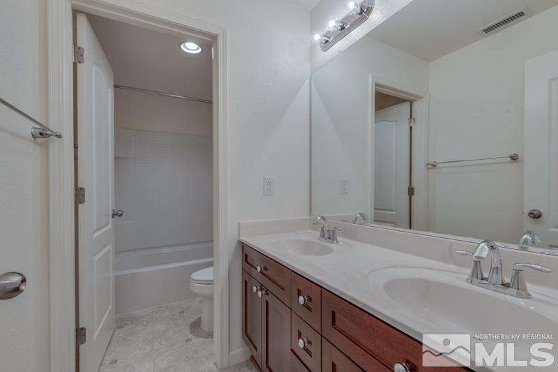 2095 Angel Ridge Drive Reno, NV 89521 - Photo 21 of 30 a bathroom with a granite countertop sink a toilet and shower