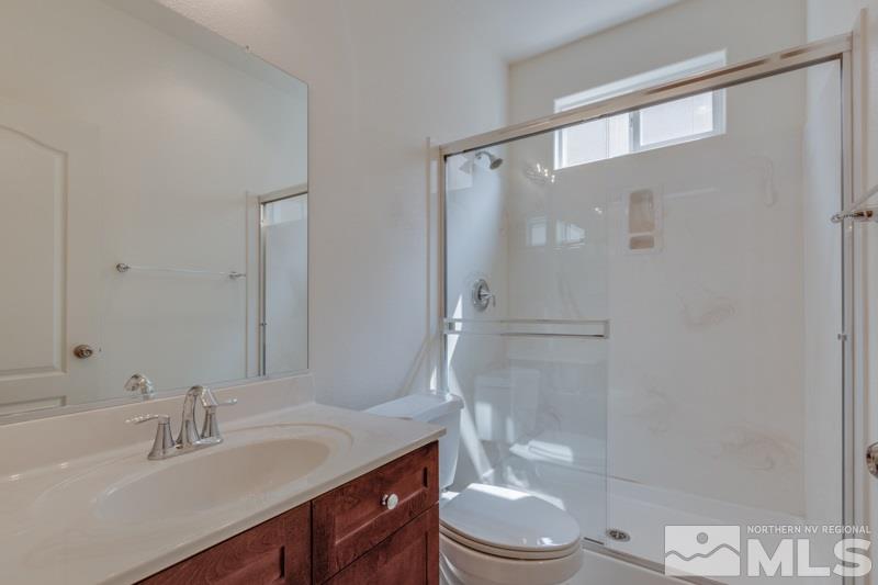 2095 Angel Ridge Drive Reno, NV 89521 - Photo 4 of 30 a bathroom with a granite countertop sink toilet a mirror and shower