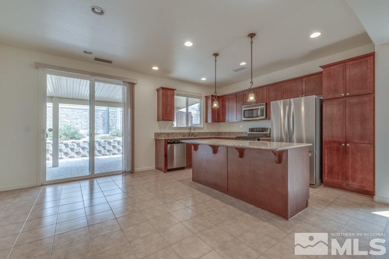 2095 Angel Ridge Drive Reno, NV 89521 - Photo 7 of 30 a kitchen with stainless steel appliances granite countertop a refrigerator a sink a stove and a wooden cabinets