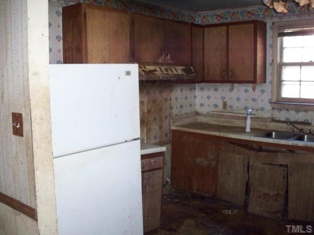 1214 Marlborough Road Raleigh, NC 27610 - Photo 4 of 4 a kitchen with a sink a refrigerator and cabinets
