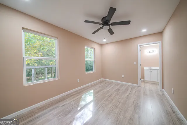 a view of a big room with wooden floor and windows