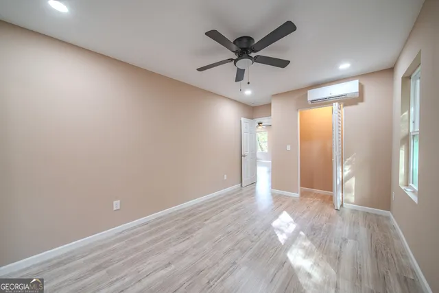 an empty room with wooden floor and windows