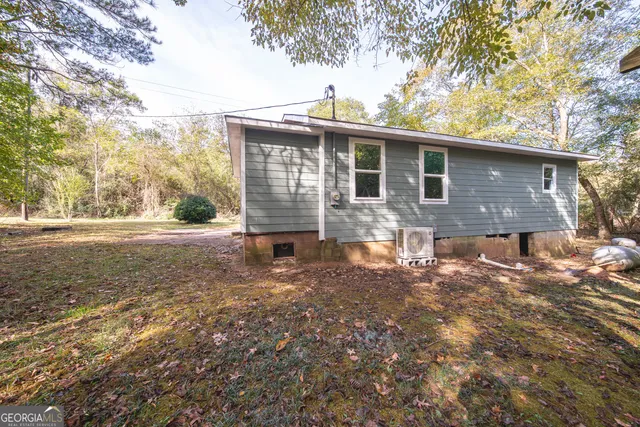 a front view of house with yard and trees around