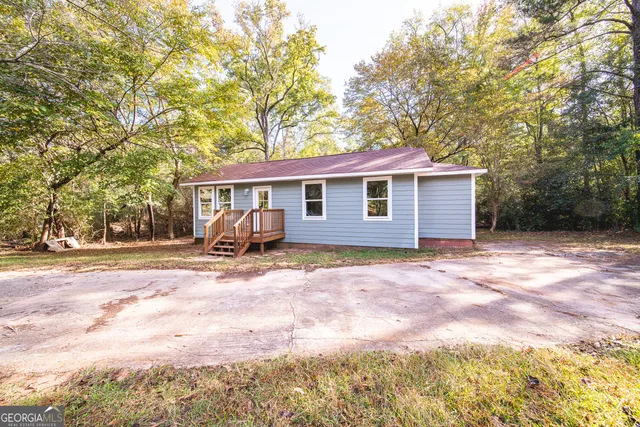 a view of a house with backyard and trees