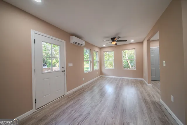 an empty room with wooden floor and windows