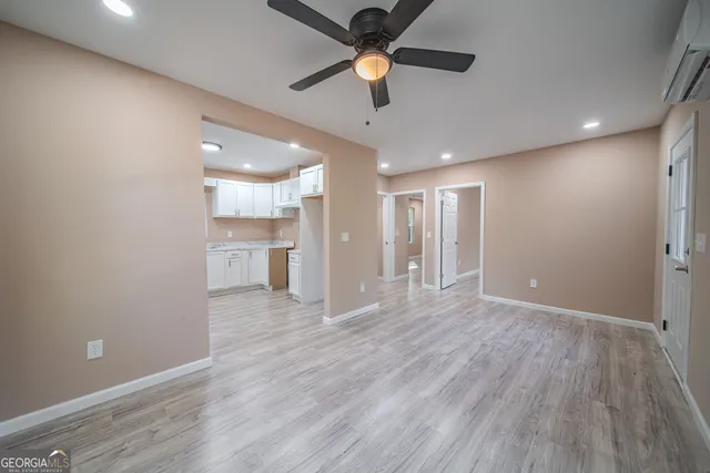 a view of an empty room with a kitchen