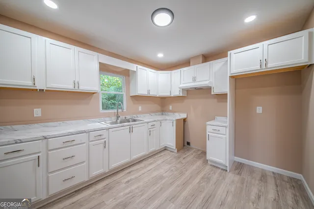 a kitchen with sink refrigerator and cabinets