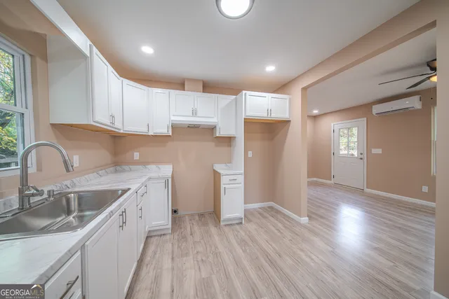 a kitchen with a sink dishwasher a refrigerator and wooden cabinets with wooden floor