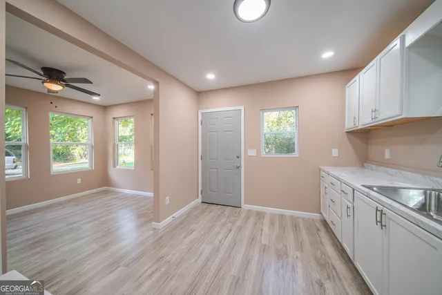 a view of a kitchen with a sink and dishwasher with wooden floor