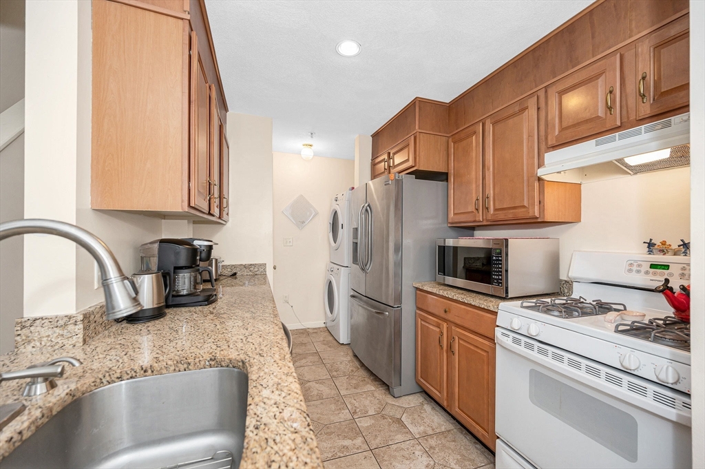 39 Broadway, Unit 305 Malden, MA 02148 - Photo 5 of 36 a kitchen with refrigerator a stove a sink and a microwave