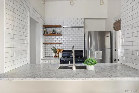 a bathroom with a granite countertop sink a potted plant and a shower