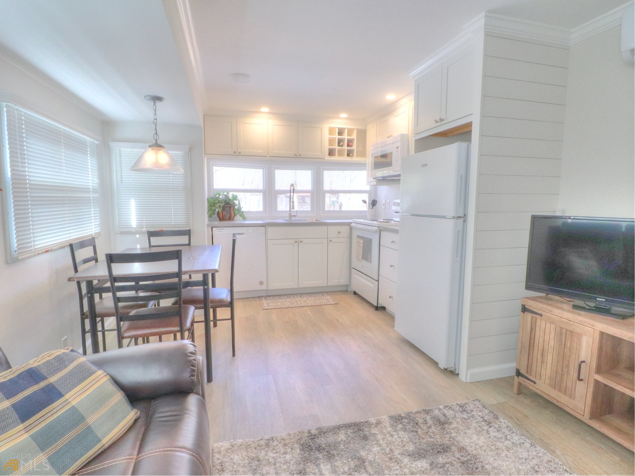 455 Hidden Valley Road Cleveland, GA 30528 - Photo 1 of 1 a kitchen with stainless steel appliances a stove a refrigerator a dining table and chairs with wooden floor