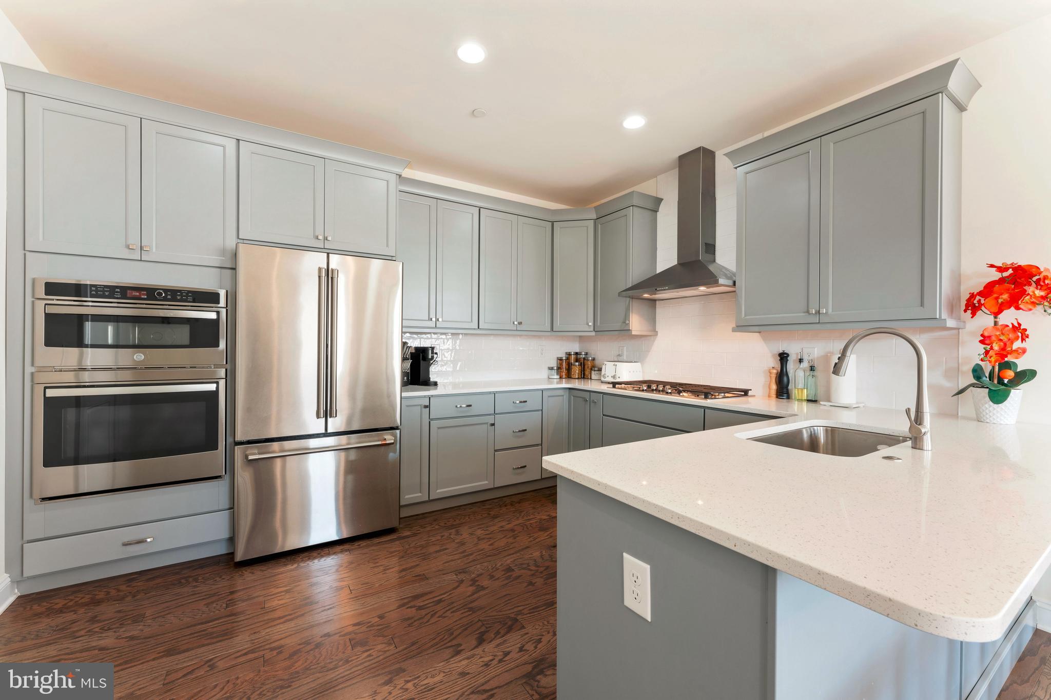 2 Parry Way Warminster, PA 18974 - Photo 11 of 41 a kitchen with a refrigerator sink and white cabinets with wooden floor
