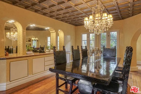 a view of a dining room with furniture a chandelier and wooden floor