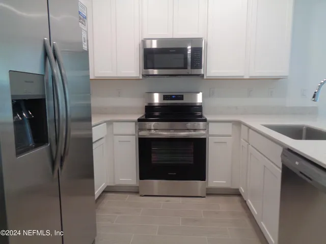 a kitchen with stainless steel appliances granite countertop a refrigerator stove and sink