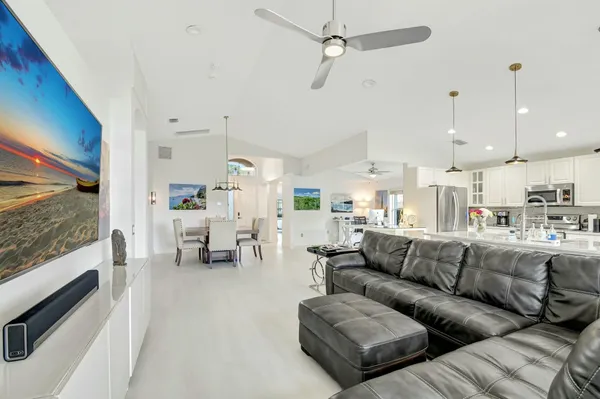 a living room with furniture kitchen view and a chandelier