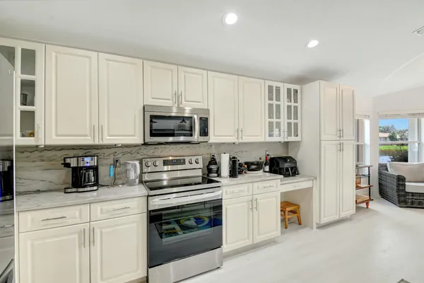 a kitchen with stainless steel appliances white cabinets and a stove top oven
