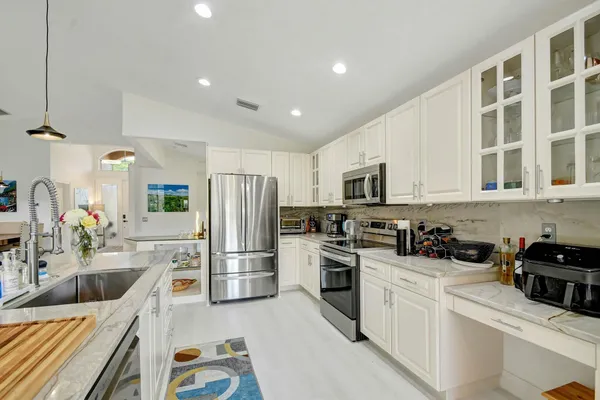 a kitchen with refrigerator a stove and a sink
