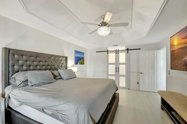 a bedroom with a large bed and a chandelier
