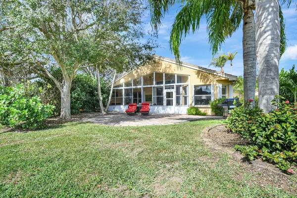 a front view of multi story residential apartment building with yard and sign board