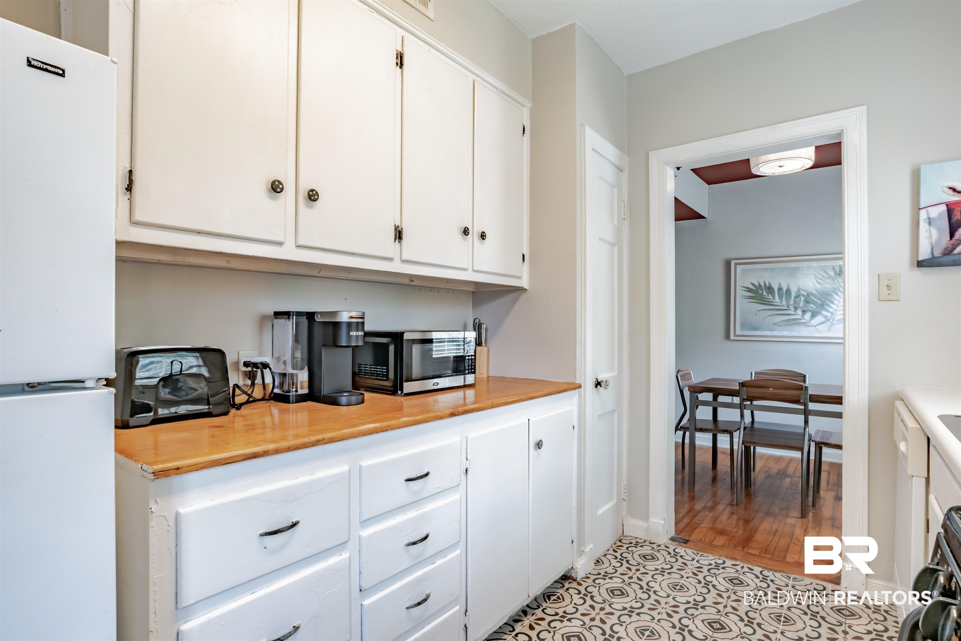 214 Upham Street, Unit 7C Mobile, AL 36607 - Photo 11 of 32 Kitchen with freestanding refrigerator, white cabinets, wooden counters, stainless steel microwave, and black range oven