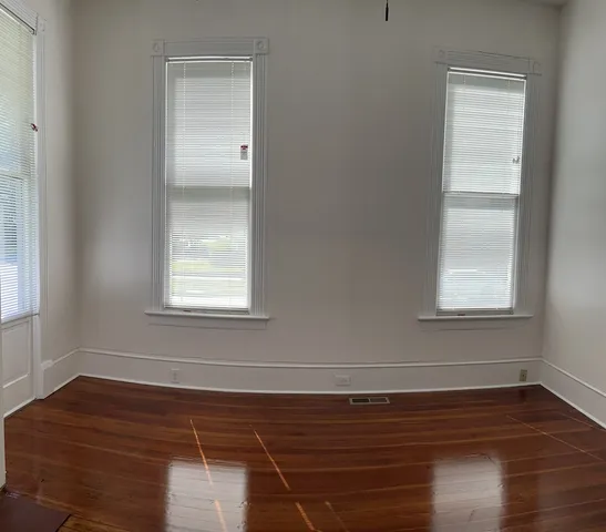 a view of a room with wooden floor and windows in it