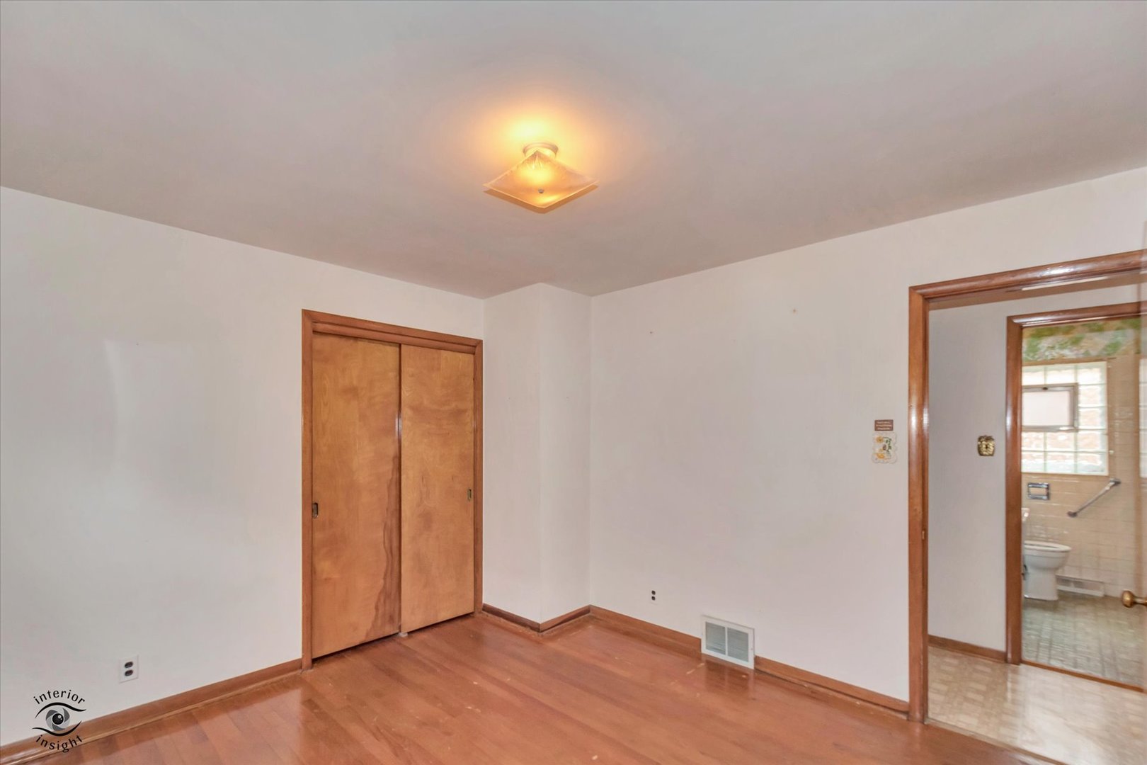 6049 South Mobile Avenue Chicago, IL 60638 - Photo 11 of 26 an empty room with wooden floor and mirror