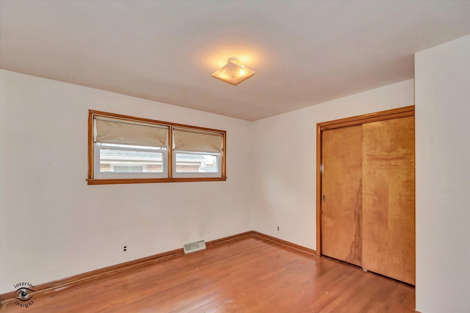 6049 South Mobile Avenue Chicago, IL 60638 - Photo 10 of 26 an empty room with wooden floor and windows