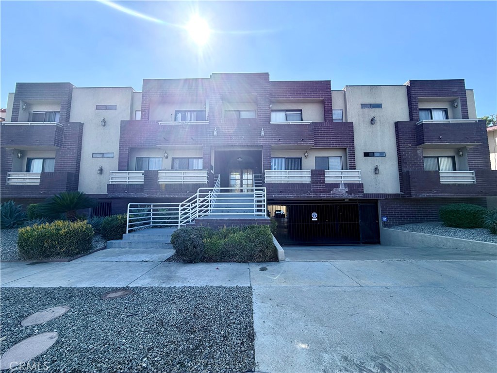 13512 Moorpark Street, Unit 103 Sherman Oaks, CA 91423 - Photo 1 of 10 a large building with a bench in front of it
