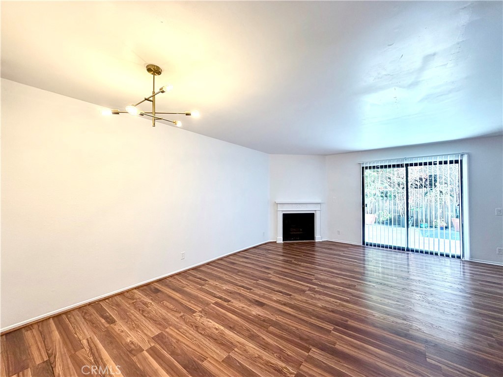 13512 Moorpark Street, Unit 103 Sherman Oaks, CA 91423 - Photo 5 of 10 a view of empty room with wooden floor and fireplace